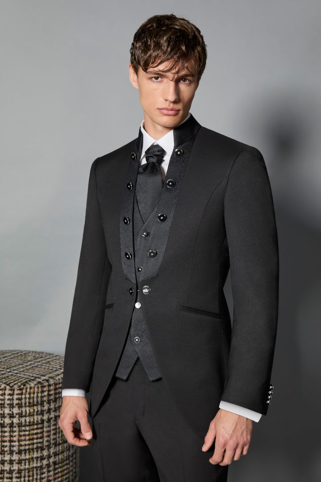 Modello indossa un abito da sposo della collezione 2026